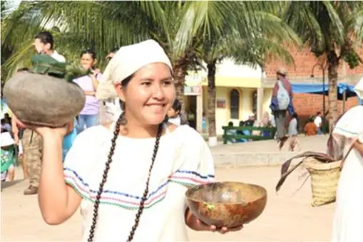 Mujer tacana con vestimenta tradicional ofreciendo tutumas